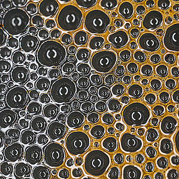 Пузыри пены разного цвета на поверхности воды