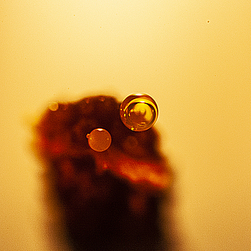 Расплавленные капельки парафина на конце фитиля свечи