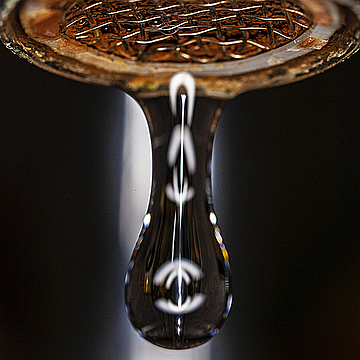 Свисающая из крана капля воды